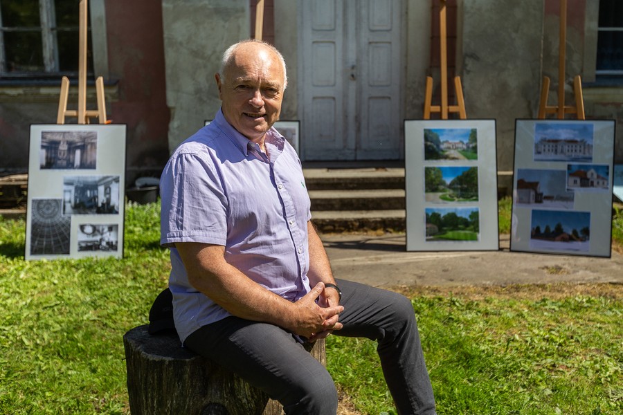Adam Sczaniecki na tle wystawy zdjęć przedstawiających pałac oraz park w Nawrze, fotografia autorstwa Szymona Zdziebło/tarantoga.pl dla Urzędu Marszałkowskiego Województwa Kujawsko-Pomorskiego
