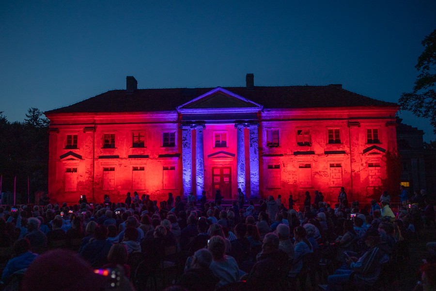 Zdjęcie przedstawia ludzi oglądających mapping przedstawiający wizualizacje rewitalizacji pałacu w Nawrze wyświetlany na jego fasadzie, fotografia Mikołaj Kuras dla Urzędu Marszałkowskiego Województwa Kujawsko-Pomorskiego