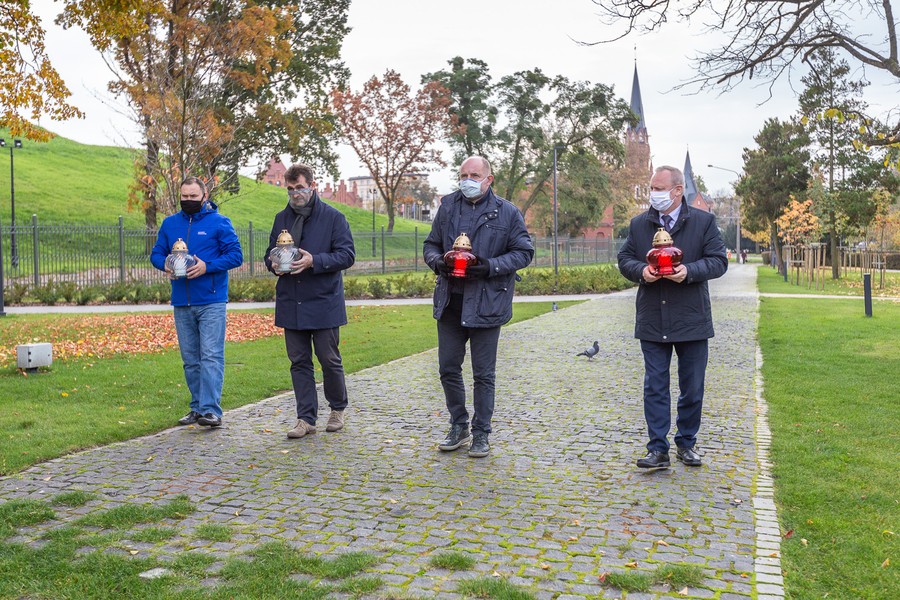 Marszałek Piotr Całbecki i towarzyszące mu osoby zapalają znicze pod pomnikiem Pamięci Ofiar Zbrodni Pomorskiej 1939, fot. Szymon Zdzieblo/tarantoga.pl dla UMWKP