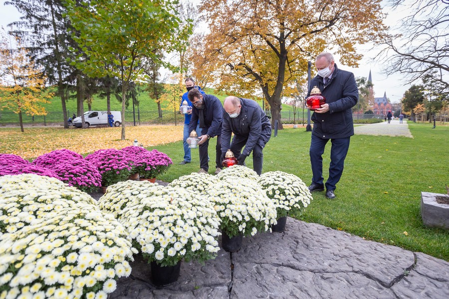 Marszałek Piotr Całbecki i towarzyszące mu osoby zapalają znicze pod pomnikiem Pamięci Ofiar Zbrodni Pomorskiej 1939, fot. Szymon Zdzieblo/tarantoga.pl dla UMWKP