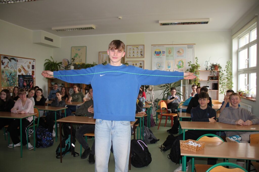 Uczeń przyrównuje rozpiętość skrzydeł bociana białego do własnych ramion, fot. D. Borzyszkowska