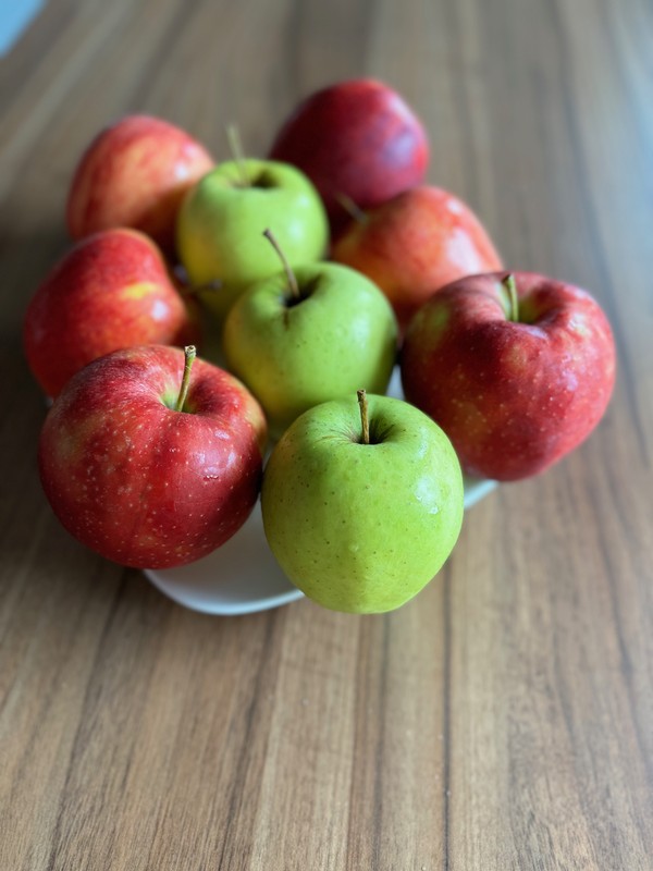 Jabłka krajeńskie na półmisku stojącym na blacie.