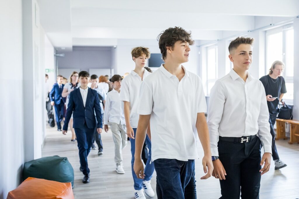 Uczniowie na korytarzu w strojach galowych