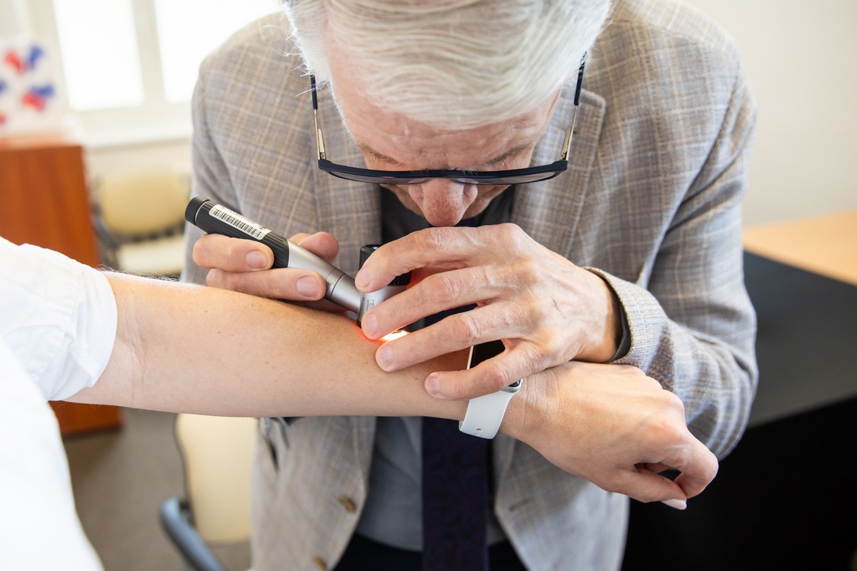 Dr Tomasz Mierzwa wykonuje badanie dermatoskopowe w kierunku czerniaka skóry, fot. Andrzej Goiński/UMWKP
