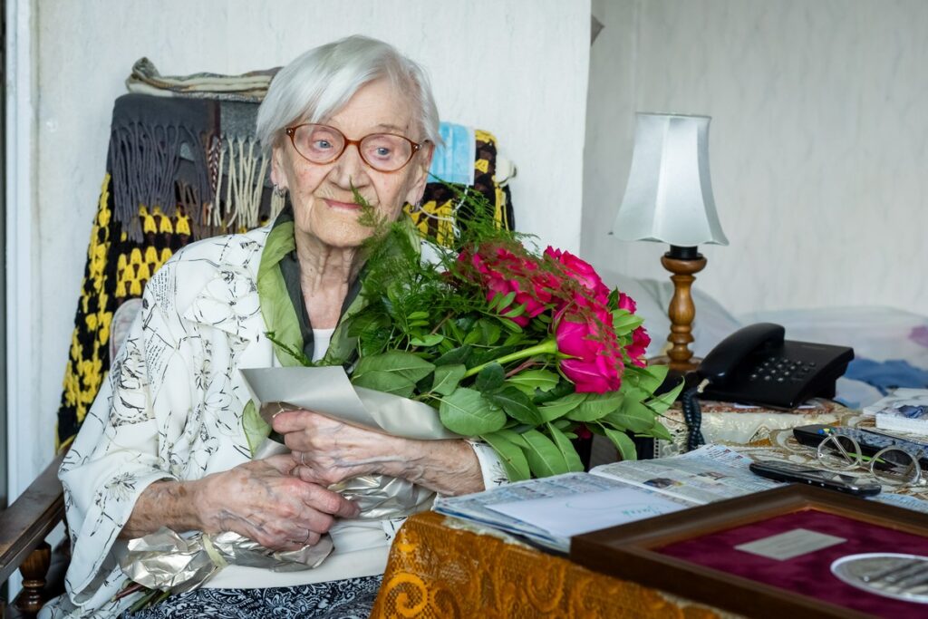 Bernadetta Kempiak z bukietem różowych róż.