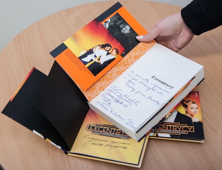 Zestaw gadżetów z filmu „Excentrycy, czyli po słonecznej stronie ulicy”: płyta z muzyką filmową, książka z autografami oraz plakat promocyjny, fot. Andrzej Goiński